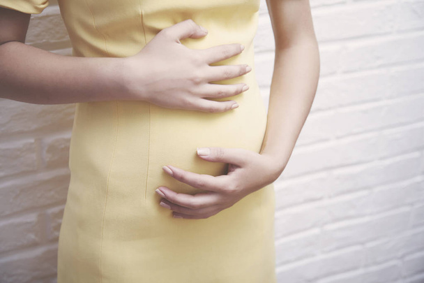 pregnant woman  in brick wall - Foto, Bild