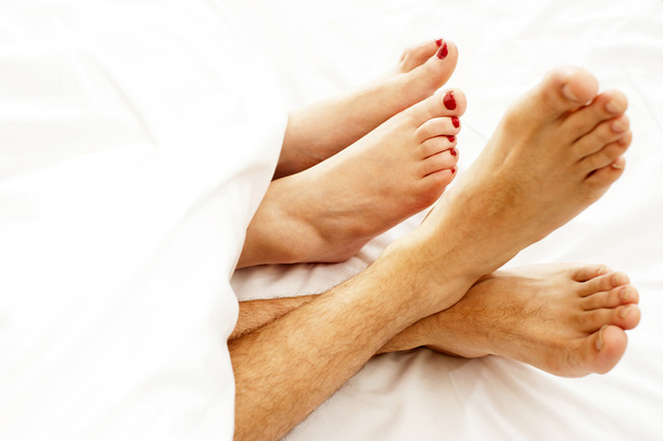 Closeup of bare feet of love couple, making out - Photo, Image