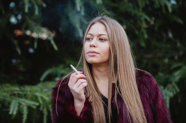 Pretty girl smoking in park - Foto, Imagem