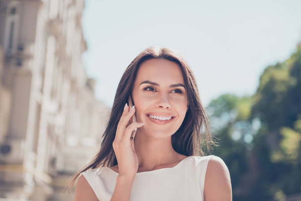 Pretty woman having business phone conversation while walking on - Фото, зображення