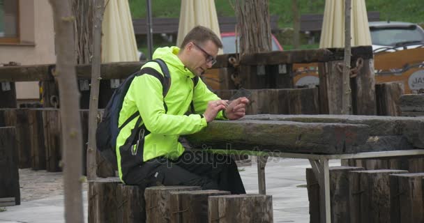 Man Shopping Texting Chatting Via Messenger Clicks Tablet in Cafe Outdoors Real Estate Purchase Doing Internet Research Young Businessman is Resting - Materiał filmowy, wideo
