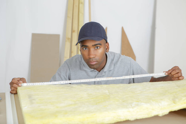 Workman measuring insulation and man - Foto, immagini