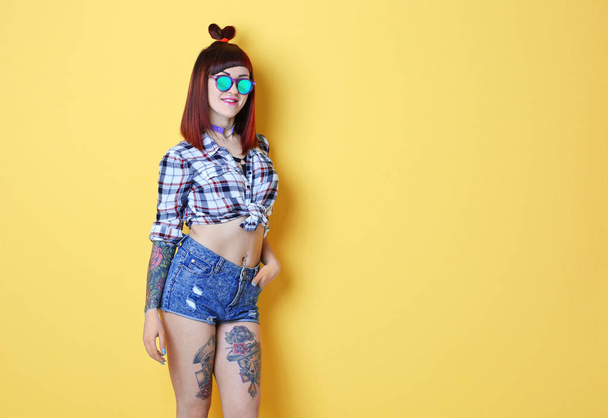 Beautiful girl with tattoo on color background - Foto, afbeelding