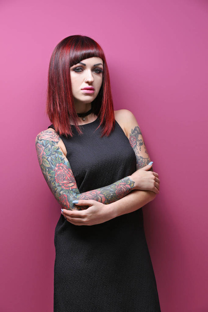Beautiful girl with tattoo on color background - Photo, Image