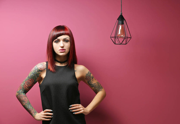Beautiful girl with tattoo on color background - 写真・画像