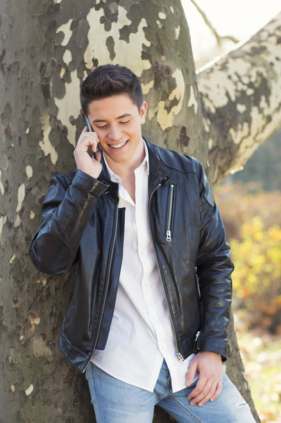 Outdoors,young man talking on phone - 写真・画像