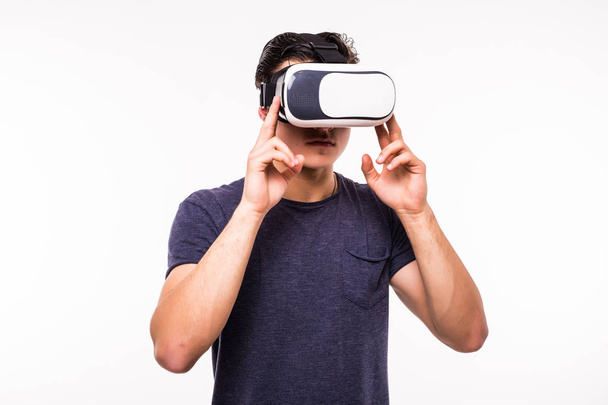 Porträt eines jungen aufgeregten Mannes, der Virtual Reality isoliert auf weißem Hintergrund erlebt - Foto, Bild