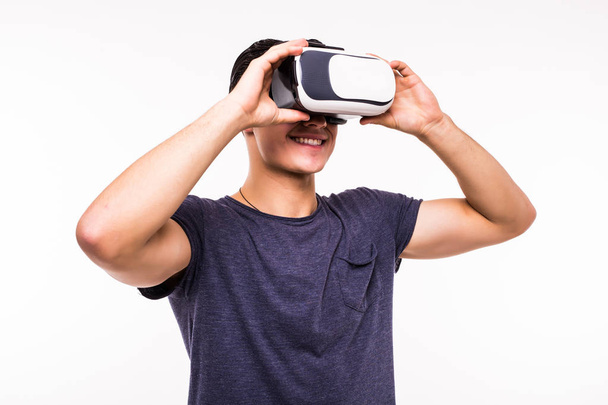 portrait of young excited man experiencing virtual reality isolated on white background - 写真・画像
