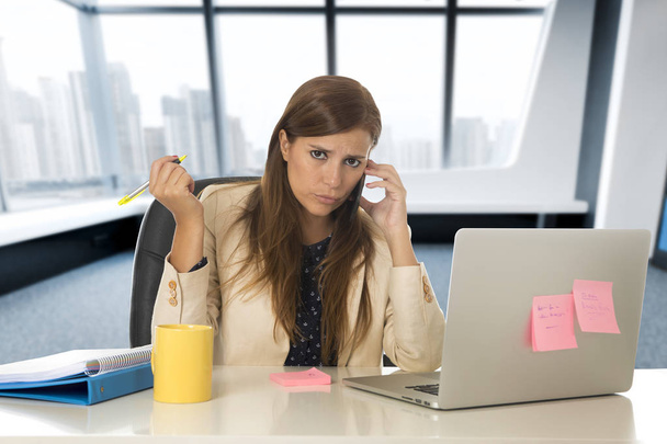 desesperada mujer de negocios que sufre estrés en escritorio de la computadora portátil de oficina
 - Foto, imagen