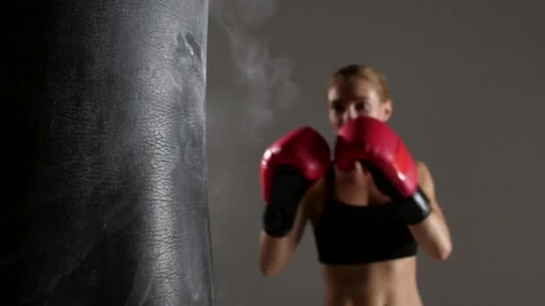 Sportswoman boxer knocks out of the punching bag. Slow motion - Video