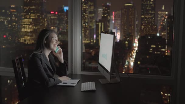 Geschäftsfrau arbeitet am Computer und telefoniert mit dem Handy - Filmmaterial, Video