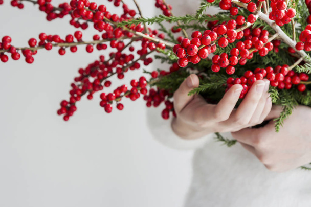 Manos de mujer sosteniendo ilex verticillata o winterberry
 - Foto, Imagen