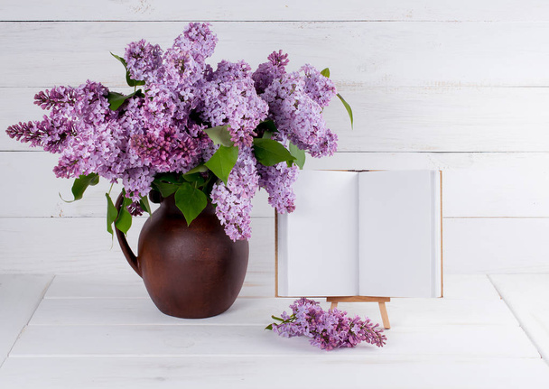 Lilac Bouquet in clay jug with open book with place for your tex - Valokuva, kuva