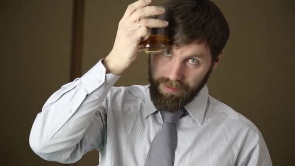 bearded business executive man yawning on a next day after a party and drink brandy from glass - Materiaali, video