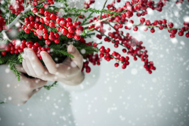 Nainen kädet tilalla ilex verticillata tai talvimarja talvella
 - Valokuva, kuva