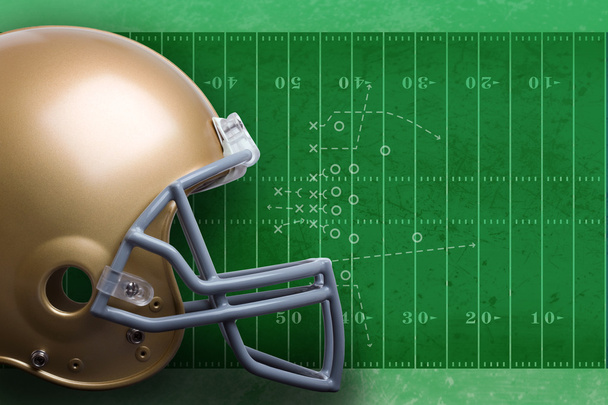Zlatá fotbalová helma v pohledu profilu proti poli s diagra - Fotografie, Obrázek