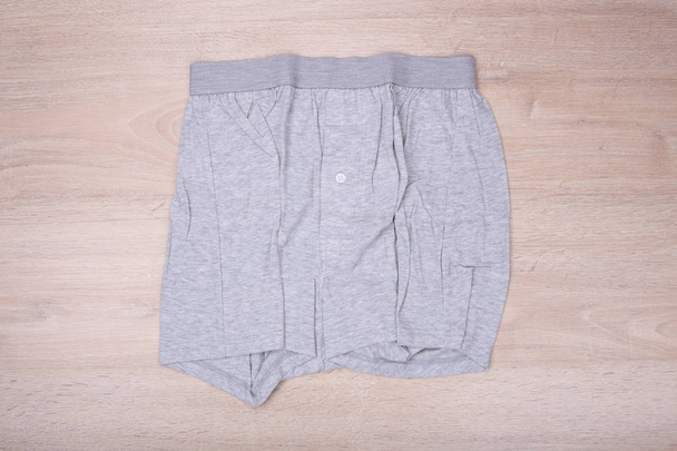 Pantalones cortos boxer gris para hombre sobre fondo de madera - Foto, Imagen