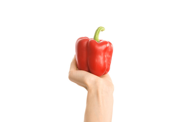 Healthy eating and diet topic: human hand holding a red pepper isolated on a white background in the studio, first-person view - Foto, Imagen