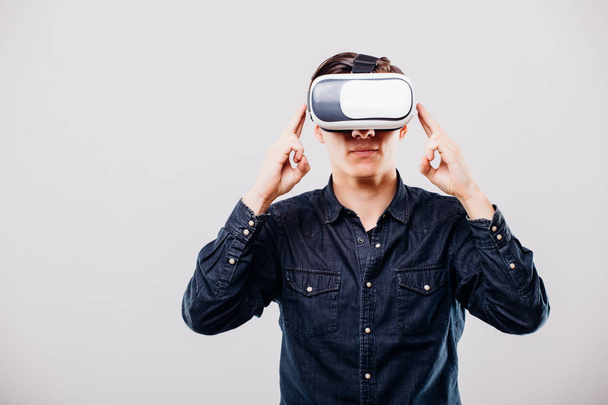 Молодой человек в очках виртуальной реальности на белом фоне
 - Фото, изображение