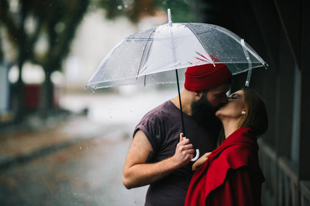 facet i dziewczyna całuje pod parasolem - Zdjęcie, obraz