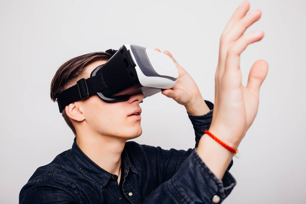 Junge Männer spielen Videospiele mit Virtual-Reality-Headset und Joystick oder fahren mit Fernbedienung. - Foto, Bild
