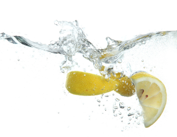 Sliced lemon in the water isolated on white - Foto, afbeelding