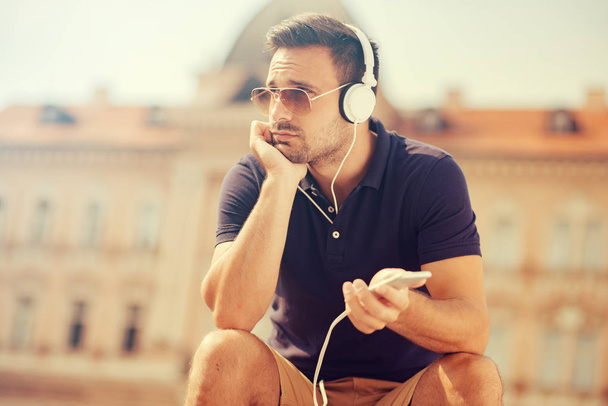 Молодой человек слушает музыку  - Фото, изображение