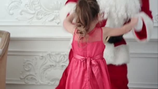 Санта и красивая маленькая девочка веселятся и танцуют
 - Кадры, видео