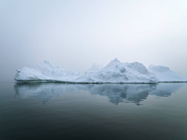Jäävuoret Grönlanti arktisella merellä. Voit helposti nähdä, että jäävuori on vedenpinnan yläpuolella ja vedenpinnan alla. Joskus on uskomatonta, että 90% jäävuoresta on veden alla.
 - Valokuva, kuva