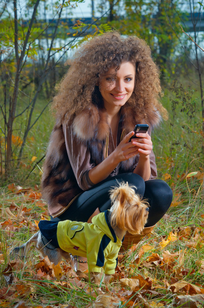 美少女が森の中で彼女の犬を抱きしめる - 写真・画像