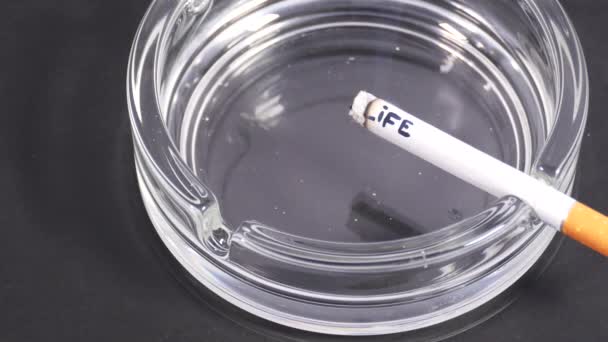 Close up cigarette with word 'life' in ashtray.  - Filmagem, Vídeo