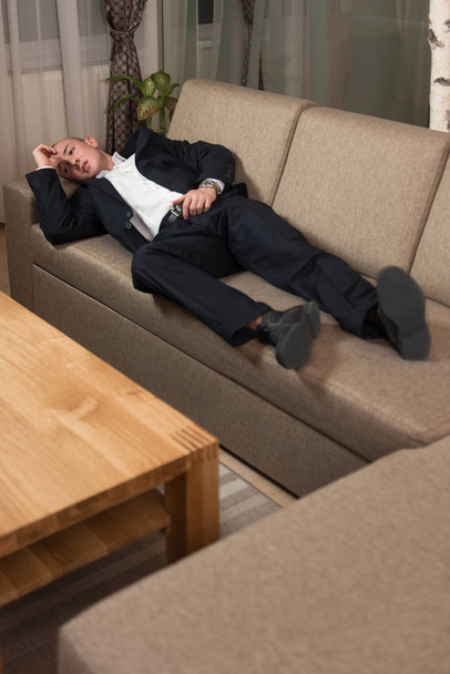 Young Businessman Resting on Sofa at Home - Фото, изображение