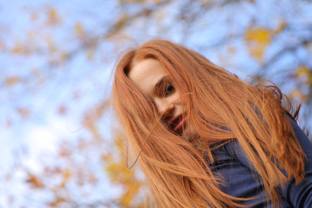 Close-up portrait of a beautiful red-headed girl posing - 写真・画像