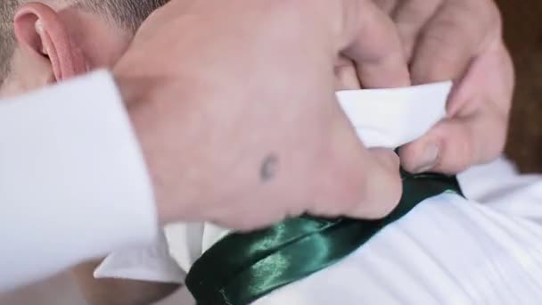 man straightens the collar on a white shirt - Materiał filmowy, wideo