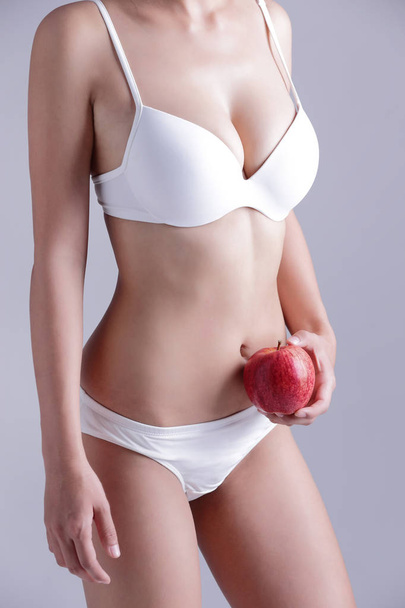 Fit woman holds apple - Zdjęcie, obraz
