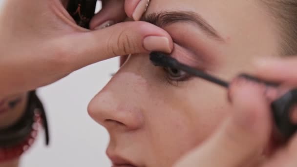 Close up shot.Professional make-up artist applying mascara on eyelashes of model - Filmagem, Vídeo