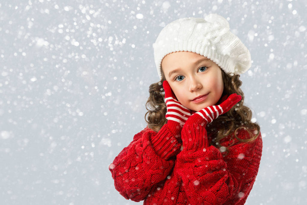 Roztomilá holčička v zimní oblečení na sníh pozadí - Fotografie, Obrázek