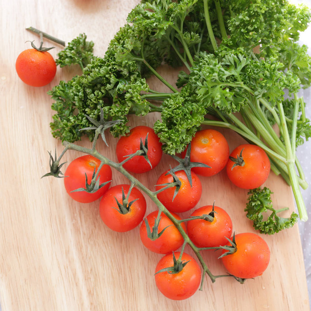 peterselie en tomaat op hakblok - Foto, afbeelding