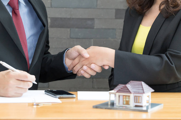Kunde schüttelt Hände und Einigung mit einem Immobilienmakler im Büro - Foto, Bild