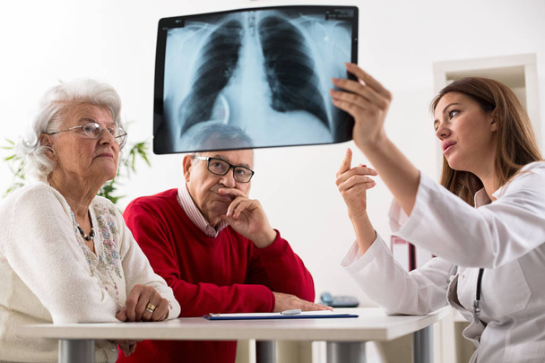 Doctor shows results to old patient x-ray of the lungs  - Foto, Bild
