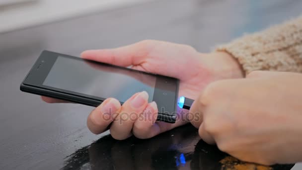 Naisten käsi kytkemällä musta salama latauskaapeli älypuhelimeen
 - Materiaali, video