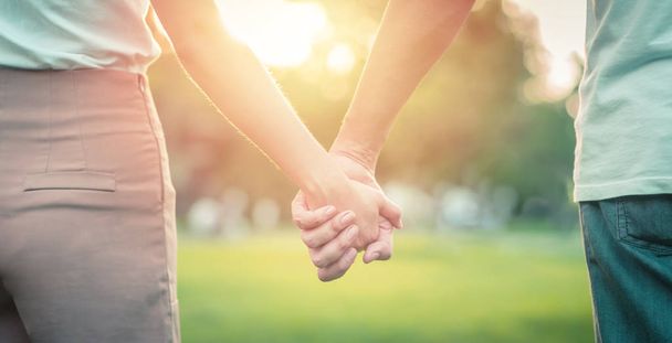 Пара влюбленных, держащихся за руки в парке
 - Фото, изображение