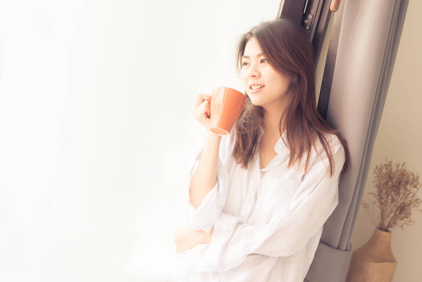 Азиатка улыбается, когда пьет кофе по утрам
 - Фото, изображение