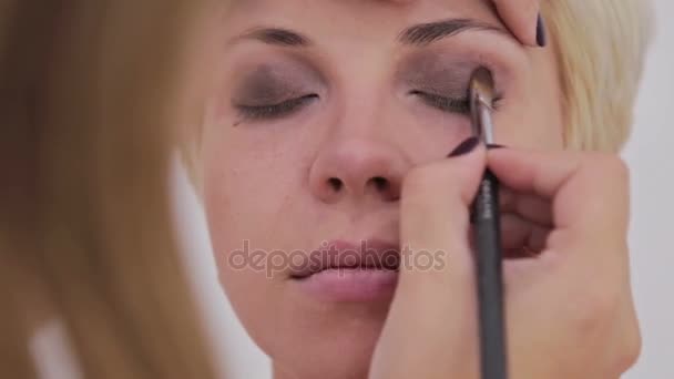 maquillador profesional aplicando sombra de ojos - Metraje, vídeo
