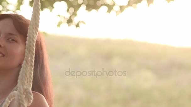 gelukkig meisje glimlachend swingen op schommel, close-up - Video