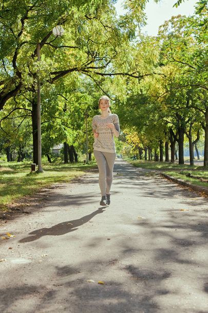 Young girl with blue eyes a joging in the park - 写真・画像
