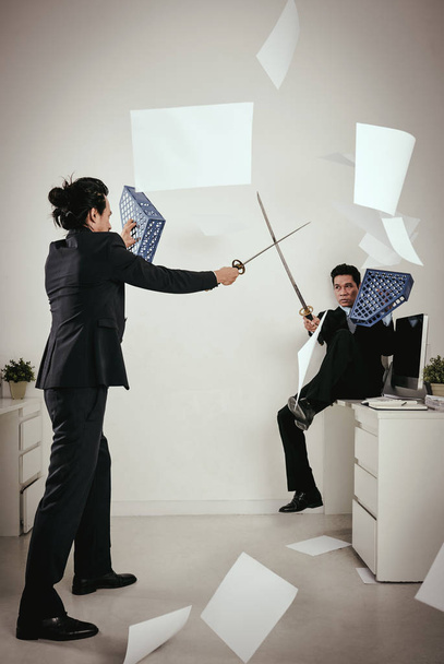 Uomini d'affari che combattono in ufficio
 - Foto, immagini