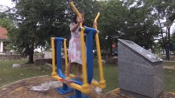 ein kleines Mädchen, das an Turngeräten trainiert, eisernes Fahrrad, - Filmmaterial, Video