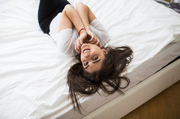 Παραπάνω άποψη του όμορφη γυναίκα στο ξαπλωμένος στο κρεβάτι - Φωτογραφία, εικόνα