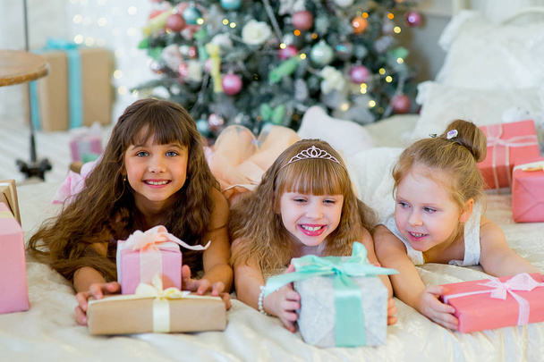 Three young happy girls with Christmas gifts - Foto, afbeelding